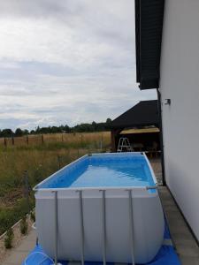 a large bath tub sitting next to a building at Beztroski Zakątek in Nowe Guty