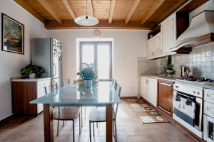 una cucina con tavolo, sedie e frigorifero di Icaro'sHouse a Pofi