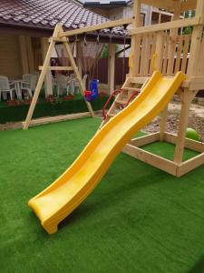 a yellow slide on a playground in a yard at Pogar White in Slavske