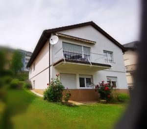 a white house with a balcony and some flowers at Milonia 2 in Bernkastel-Kues