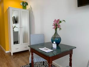 un vaso di fiori su un tavolo con un mobile di Central - São Pedro Boutique a Funchal