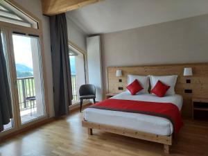 a bedroom with a large bed with red pillows at AUBERGE DES GLIERES in Thorens-Glières