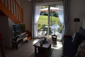 a living room with a couch and a television and a table at location maison à Cajarc 46160 (Lot) in Cajarc