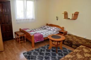 Schlafzimmer mit einem Bett, einem Tisch und Stühlen in der Unterkunft U Janusza in Zadwórze
