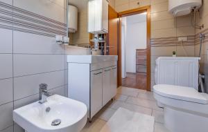 a bathroom with a white toilet and a sink at Apartments Larst in Medulin