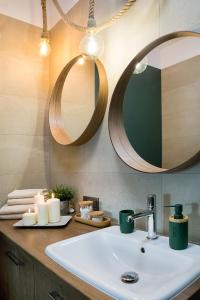 a bathroom with a sink and a mirror and candles at W&K Apartments - Energy Suite - Faktura VAT, Parking in Koszalin