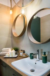 a bathroom with a sink and a mirror and candles at W&K Apartments - Energy Suite in Koszalin