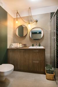 a bathroom with a toilet and two mirrors at W&K Apartments - Energy Suite in Koszalin
