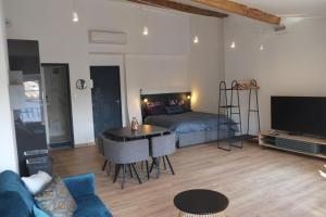 Sala de estar con cama, mesa y TV en A l'ombre des remparts, en Carcassonne