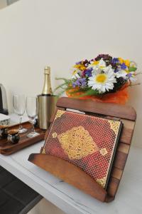 ein Tisch mit einem Buch und ein paar Gläsern und Blumen in der Unterkunft BLISS HOUSE Oradea in Oradea