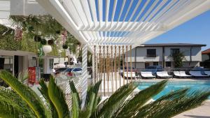 a white pergola next to a swimming pool at Ella Luxury Apartament in Năvodari
