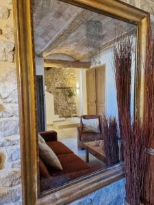 a mirror in a living room with a couch and a chair at Mas des Aïeux in Laudun