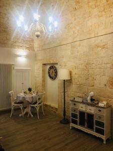 een eetkamer met een tafel en een klok aan de muur bij Nido di pietra-dimora in centro in Alberobello