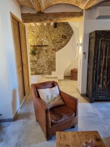 a living room with a leather chair and a table at Mas des Aïeux in Laudun +21 photos