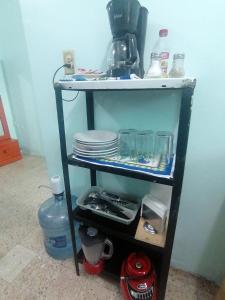 a shelf with plates and other items on it at DEPARTAMENTO CERCANO AL AEROPUERTO T2, A 2 CALLES in Mexico City