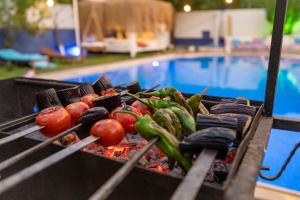a grill with tomatoes and other vegetables next to a pool at B&B Boutique Hotel in Dalyan