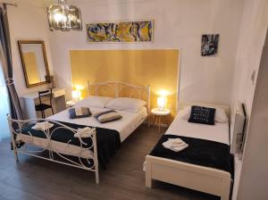 two beds in a small room with two lamps at Apartman Plasse in Rijeka