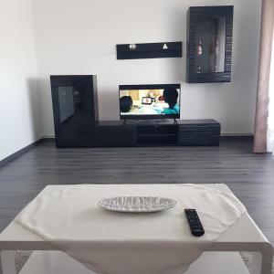 a remote control sitting on a table in front of a tv at Arrami Aparthotel in Satu Mare