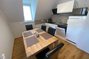 a kitchen with a wooden table with chairs and a kitchen at 3-Zimmer Wohnung für Familien & Gruppen, gemütliche Atmosphäre, hell und komfortabel in Borna