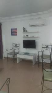 a living room with a tv and a table and chairs at MIRADOR del BALCON DE EUROPA 1A - Nerja in Nerja +4 photos