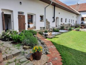 un cortile con un sentiero in mattoni e fiori in un cortile di Statek u kapličky a Skalka