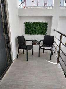 two chairs and a table on a balcony at Casa Esencia in Cozumel