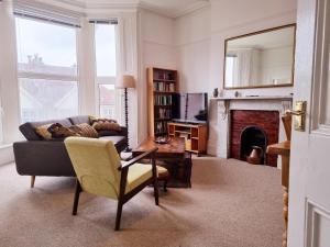 uma sala de estar com um sofá e uma lareira em Bright, character 3 bed Apartment: 7 mins walk to sea em Portsmouth