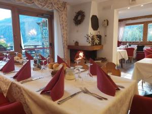 una sala da pranzo con tavolo, sedie e camino di Chalet Fiocco Di Neve a Pinzolo