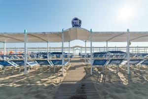plaża z leżakami i dużym parasolem na piasku w obiekcie Hotel Diplomatic w mieście Riccione