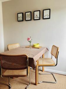 a dining room table with chairs and a vase of flowers on it at urbanAPARTMENT No.1 Memmingen in Memmingen