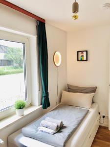 uma cama num quarto com uma janela em urbanAPARTMENT No.1 Memmingen em Memmingen