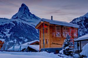 una baita di tronchi con una montagna sullo sfondo di Chalet Schwalbennest a Zermatt