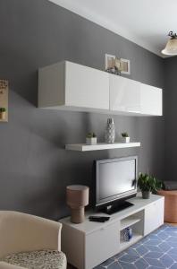 a living room with a tv on a white entertainment center at Two bedroom apartment, two minutes from the beach in Nazaré