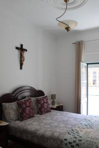 a bedroom with a bed with a cross on the wall at Two bedroom apartment, two minutes from the beach in Nazaré