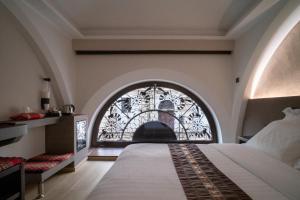 a bedroom with a bed and a window at ARCADIAN suite&rooms in Turin