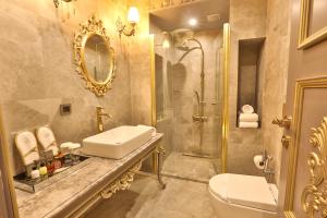 REAL KiNG SUiTE HOTEL في طرابزون: حمام مع حوض ومرحاض ودش