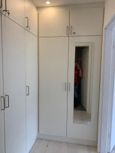 a man taking a picture of a room with white cabinets at Haus am Sonnenberg,Todtnauberg, Ferienwohnung 105, direkt am Skilift-Skipiste, Nähe Feldberg in Todtnauberg