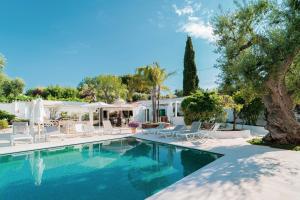 a swimming pool with lounge chairs and a house at B&B Antico Ulivo in Monopoli