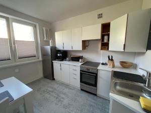 a kitchen with white cabinets and a stove top oven at Apartament Basia in Gdynia