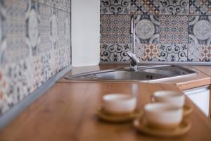 uma cozinha com um lavatório e duas chávenas num balcão em Apartament Paderewskiego 20A em Przemyśl
