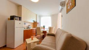 a living room with a couch and a kitchen at Apartments Dario in Medulin