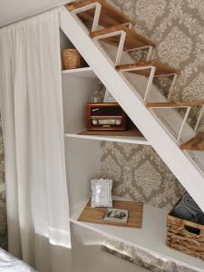 a book shelf under a staircase in a bedroom at Sapņi in Kolka