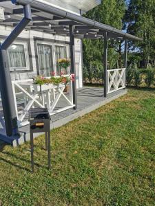 a house with a deck with flowers on it at Sapņi in Kolka