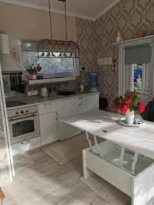 a kitchen with a white table and a stove at Sapņi in Kolka