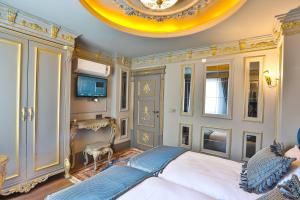 een slaapkamer met een groot bed en een plafond bij REAL KiNG SUiTE HOTEL in Trabzon