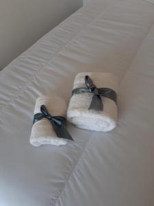 two towels with black bows on a bed at Parque Patricios 2 ambientes in Buenos Aires