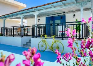 a yellow bike parked on a balcony with pink flowers at Relax Studios in Limenaria +12 photos