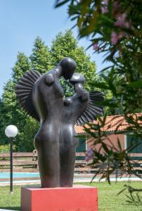 a bronze statue of a woman with her wings out at Relais Villa Isabel in Pietrasanta
