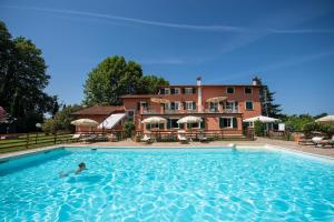 a person in a swimming pool in front of a building at Relais Villa Isabel in Pietrasanta