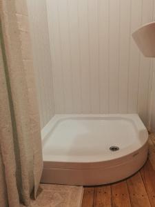 a white bath tub in a bathroom with a curtain at Каравана Бохемия in Chernomorets